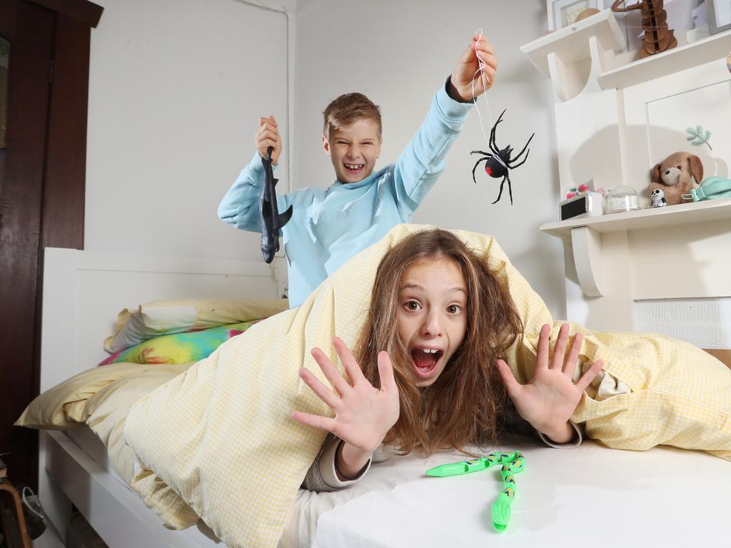 Why pranking could be good for the soul (without going too far). Lifestyle and playful photos of Emily, her husband and their two kids in the yard with pranking props (rubber snakes/spiders). Colourful and casual clothing, eyes to camera shots for SMARTdaily cover photo.    Cassie, 10, and Jake, 8, in their room. Picture: Alex Coppel.
