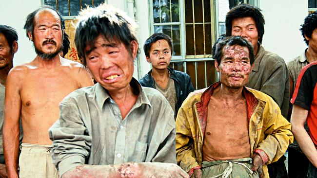 Rescued workers standing outside a police station after they were saved from brick kiln in Linfen, north China's Shanxi province.