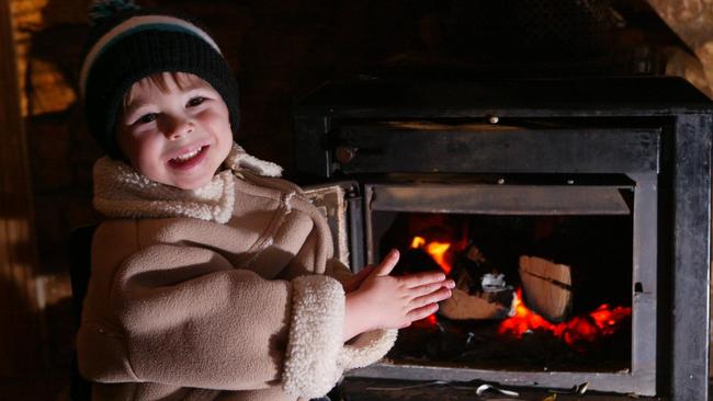 Joel Atkinson, 3, keeps warm by the fire at the Globe Hotel, Yongala, the coldest town in SA. Photo: James Elsby/The Advertiser.