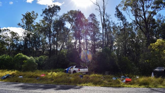 MOONIE CRASH: Remnants of the family’s life was strewn across the rural highway – taped up boxes, a child’s skateboard, a dog bowl, camping gear, bikes and an Esky. Pic: Peta McEachern