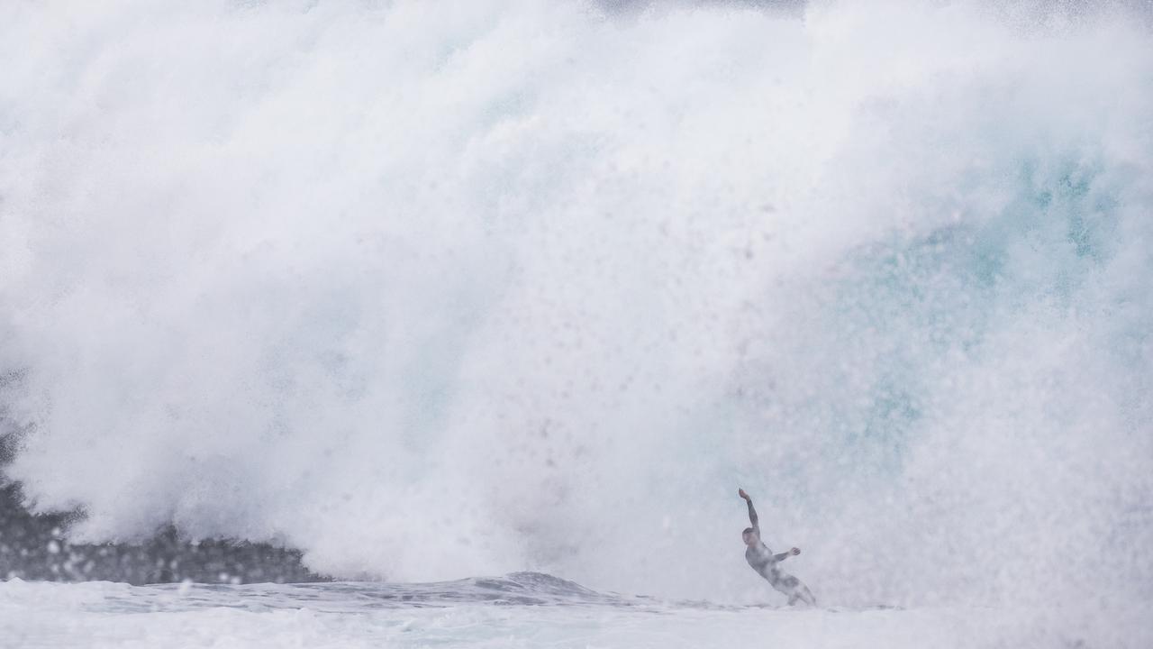 Surfers use jet skis to tow into large waves still around from the low pressure system at the Cape Solander surf break "Ours". Picture: Dylan Robinson