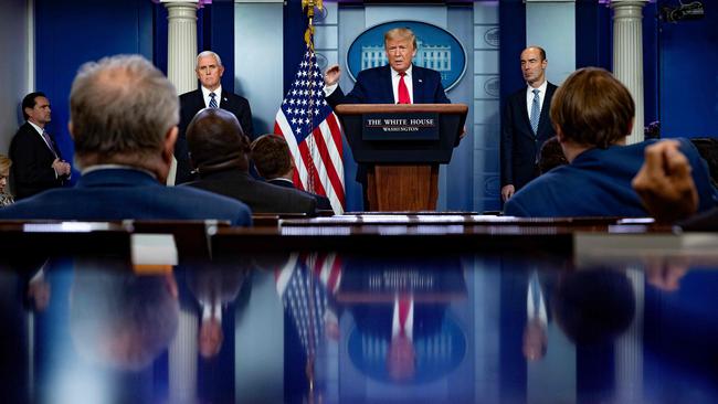 US President Donald Trump speaks, flanked by US Vice President Mike Pence (L) and US Secretary of Labor Eugene Scalia (R) during the daily briefing on the novel coronavirus.