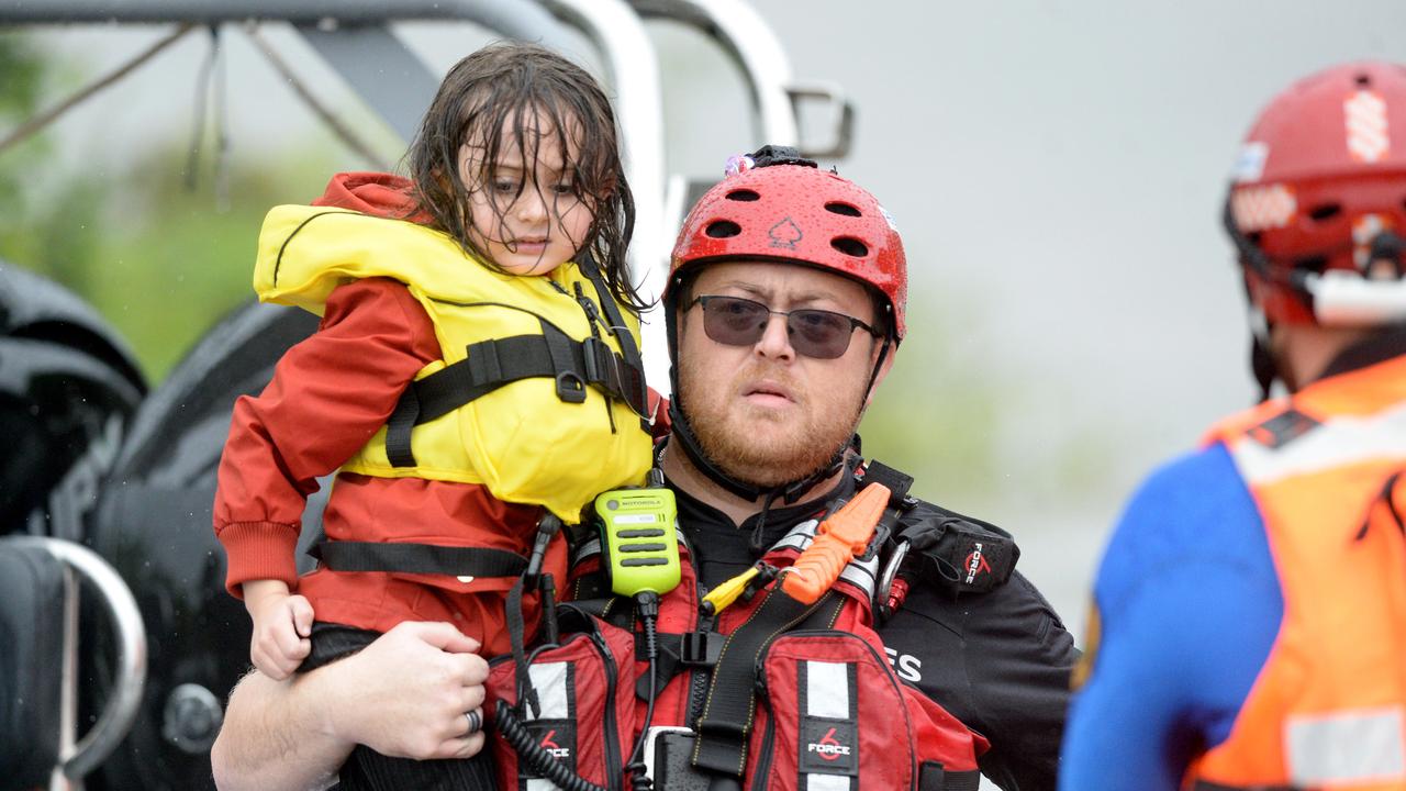 A family is brough to safety after their rescue vessel capsized in the Hawkesbury River in Sackville, NSW, on Tuesday. Picture: Jeremy Piper