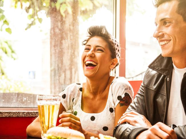 Friends enjoy together dinner in a cafe. 50s style.