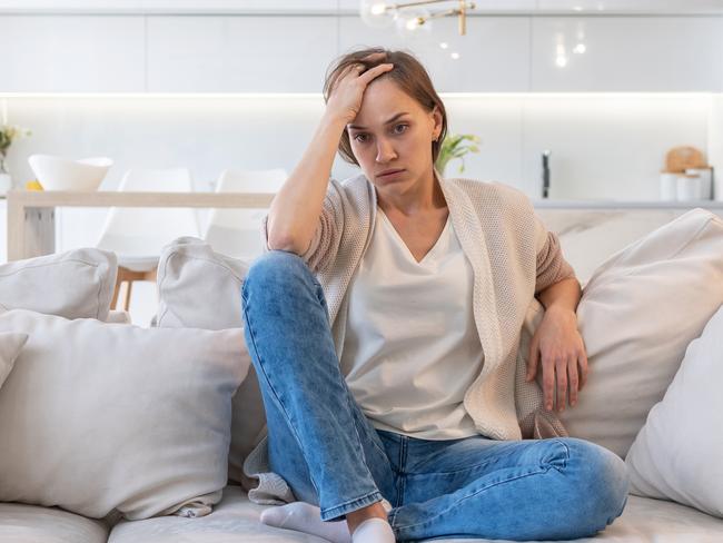 MENTAL HEALTH -  Tired and upset woman sitting on the couch at home Picture: Istock