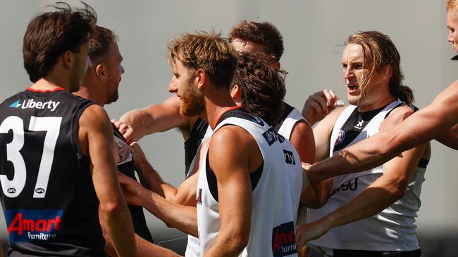 Redman removes his mouthguard as the pair exchange some choice words. Picture: Michael Willson/AFL Photos via Getty Images