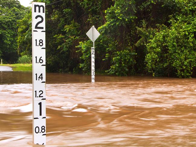 A flooded road with depth indicators in Queensland, Australia