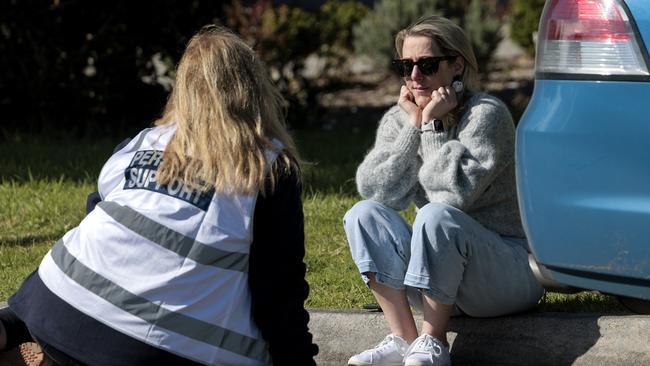 A woman receives counselling at the scene of the fatal house fire in Mooroolbark. Picture: David Geraghty