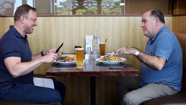 Premier Steven Miles tuckers into a steak with journalist Michael Madigan at the Murrumba Downs Tavern. Picture: David Clark