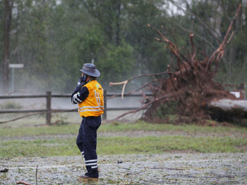 Energex workers tend to fallen trees across a road after a super cell storm tore through Long Flat south of Gympie. Photo Lachie Millard