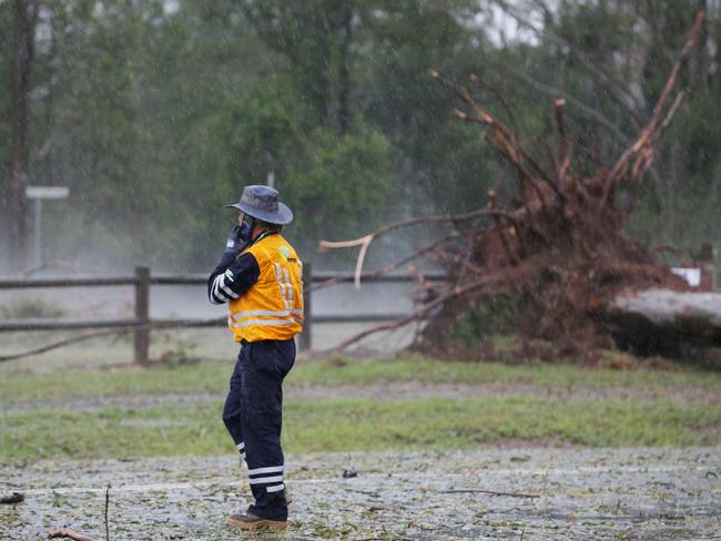 Energex workers tend to fallen trees across a road after a super cell storm tore through Long Flat south of Gympie. Photo Lachie Millard