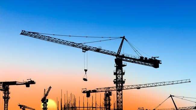 Crane and building construction site at sunset