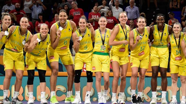 Australia players celebrate on the podium with their silver medals.