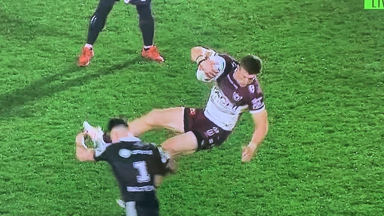 Manly’s Reuben Garrick is tackled in mid-air by NZ Warriors fullback Charnze Nikoll-Klokstad in Auckland last night.