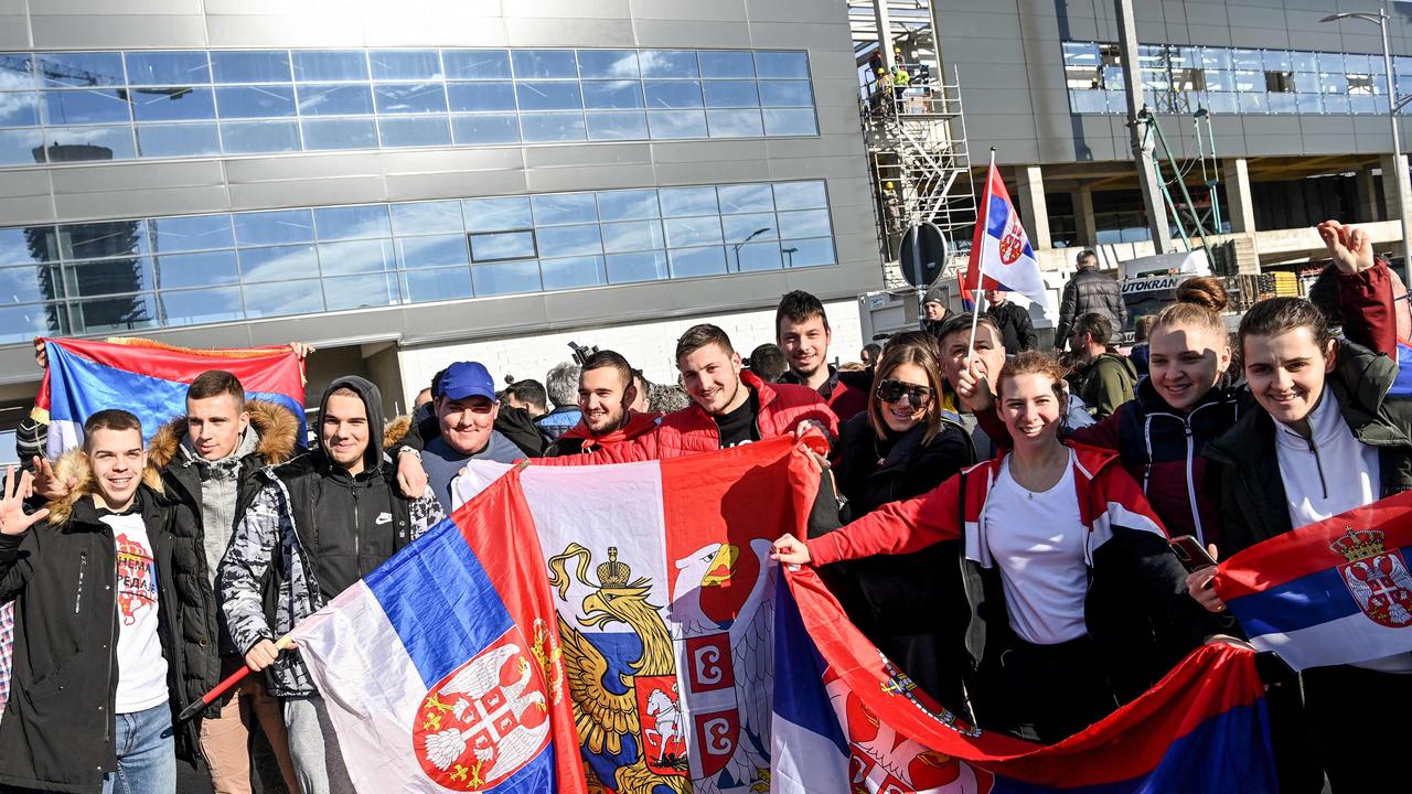 People held Serbian national flags as they awaited the arrival of Djokovic in Belgrade. Picture: AFP.
