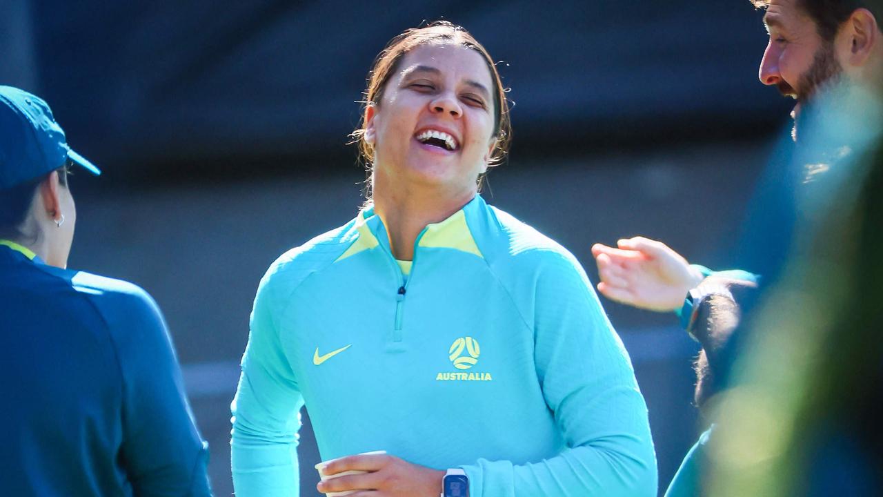 Injured Australian captain Sam Kerr (C) laughs with coaching staff before a training session at Perry Park in Brisbane on July 26, 2023 ahead of their match against Nigeria in the Women's World Cup football tournament. (Photo by Patrick HAMILTON / AFP)