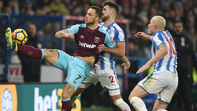 West Ham United's Austrian midfielder Marko Arnautovic (L) controls the ball under pressure from Huddersfield Town's English defender Tommy Smith (C) and Huddersfield Town's Australian midfielder Aaron Mooy (R)