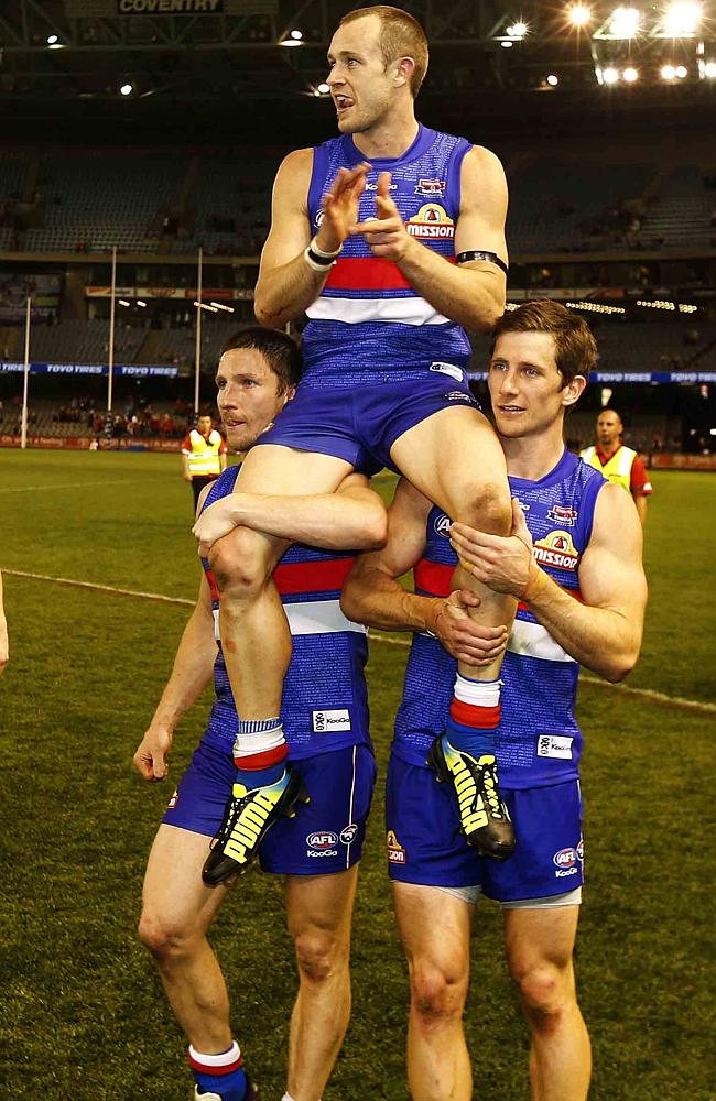 Cross is chaired off by then teammates Matthew Boyd and Dale Morris. Picture: Michael Klein