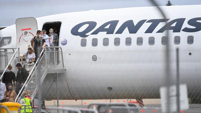 Passengers wearing face masks arrive on a Qantas flight into Ballina Byron Gateway Airport on April 01. Trans-Tasman travellers will be required to wear face masks under strict trans-Tasman protocols. Picture: James D. Morgan/Getty Images