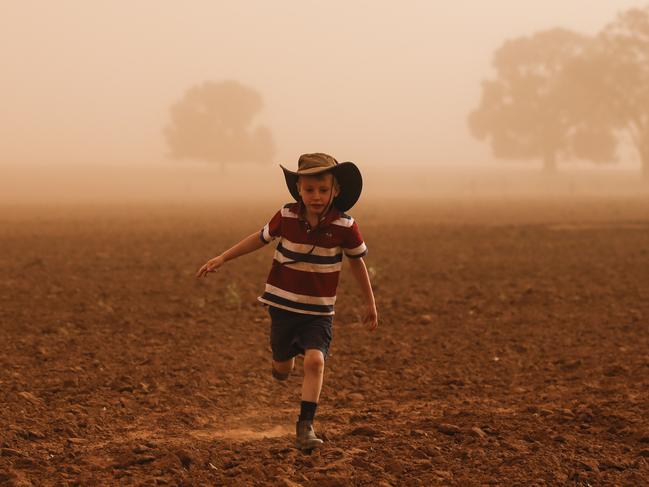 Edward Cox, 5, in a dust storm on his family's property near Collie, north of Dubbo. Picture: Dylan Robinson