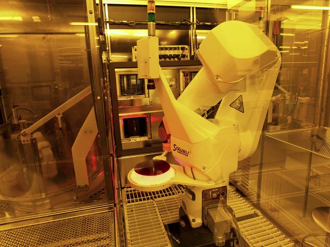 A robotic arm is used to produce a silicon wafer in a specially-lit clean room at the Texas Instruments semiconductor fabrication plant in Dallas, Texas, U.S., on Tuesday, June 16, 2009. Texas Instruments Inc., the second-largest U.S. semiconductor maker, reported sales and profit that beat analysts' estimates on stronger demand for chips used in mobile phones and communications networks in China. Photographer: Jason Janik/Bloomberg News