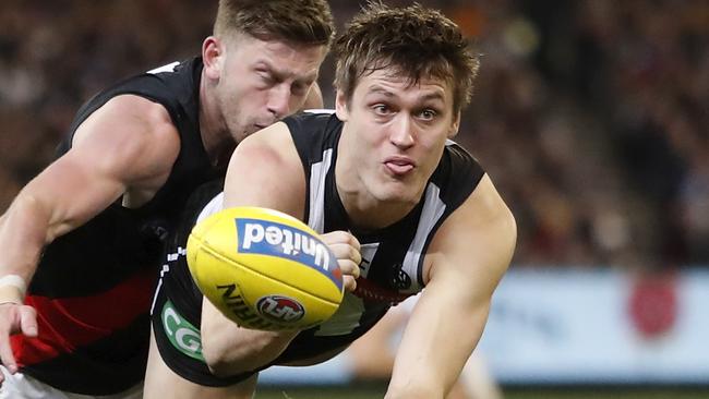 MELBOURNE, AUSTRALIA - AUGUST 23: Darcy Moore of the Magpies handpasses the ball during the 2019 AFL round 23 match between the Collingwood Magpies and the Essendon Bombers at the Melbourne Cricket Ground on August 23, 2019 in Melbourne, Australia. (Photo by Dylan Burns/AFL Photos via Getty Images)