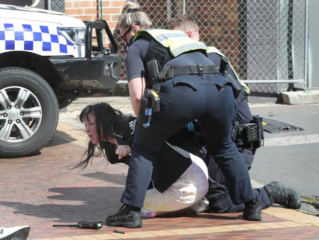 A woman claiming to be Preston’s wife is restrained by police at the scene of his murder. Picture: David Crosling