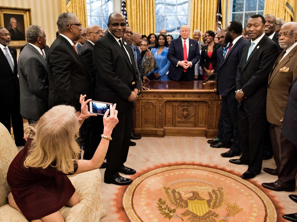 Counsellor to the President Kellyanne Conway takes a photo as US President Donald Trump and leaders of historically black universities and colleges talk before a group photo in the Oval Office of the White House before a meeting with US Vice President Mike Pence. Picture: AFP