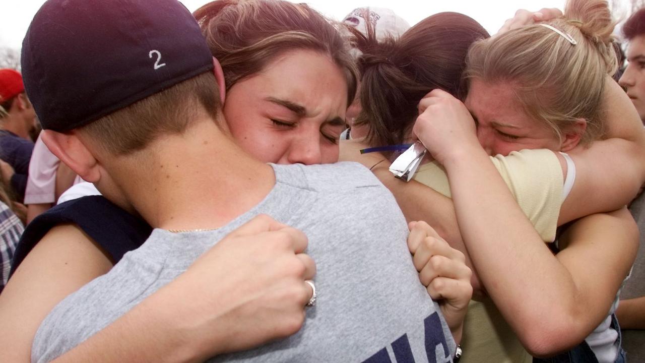 April 21, 1999: Students hug each other in the parking lot outside Columbine High School. Picture: AP 