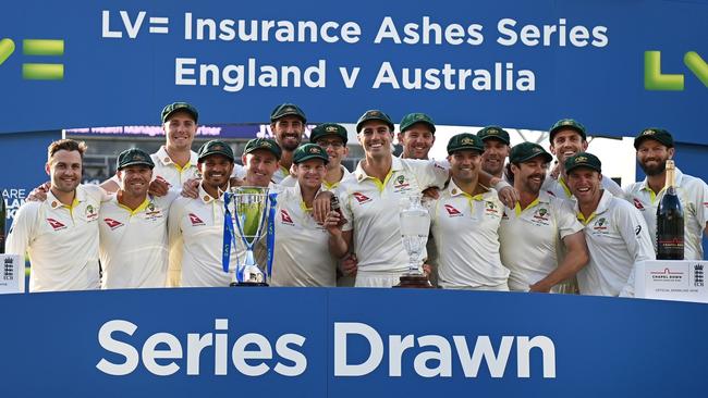 Pat Cummins of Australia lifts the Ashes Urn alongside teammates.