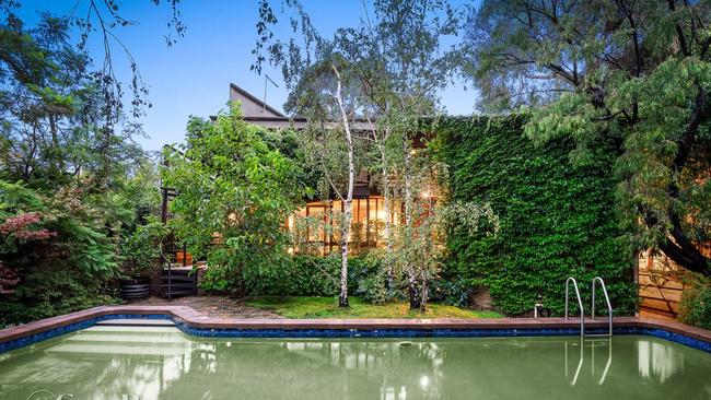 The home’s lush backyard features a pool.