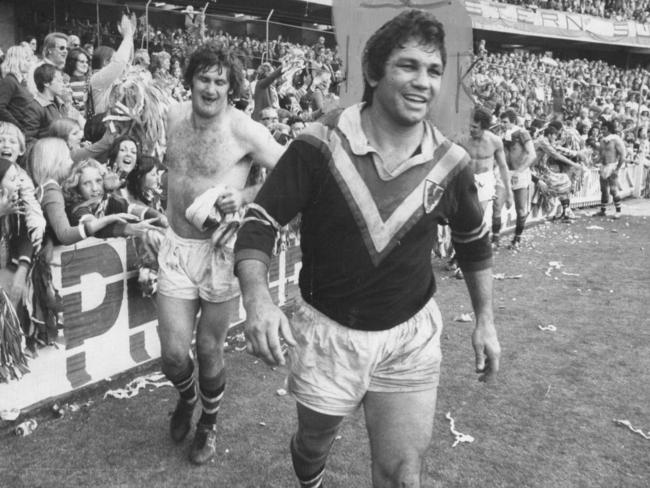 Arthur Beetson (right) and Bill Mullins after shaking hands with fans after winning the grand final against St George at the SCG in September 1975.