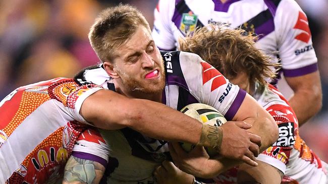 Cameron Munster of the Storm is tackled by the Brisbane Broncos.