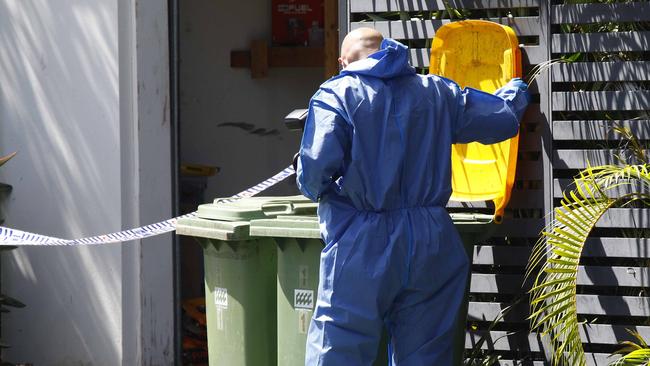 A Queensland Police officer checks a rubbish bin. Picture: Tertius Pickard