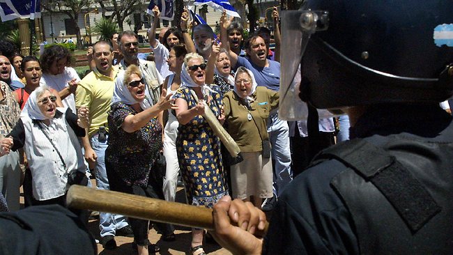 Mothers of the Plaza de Mayo, a group representing people whose family members disappeared during Argentina's military dictatorship face off with police in central Buenos Aires in 2001.