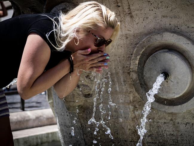 A tourist cools off at the Barcaccia fountain by the Spanish Steps in central Rome. Picture: AFP