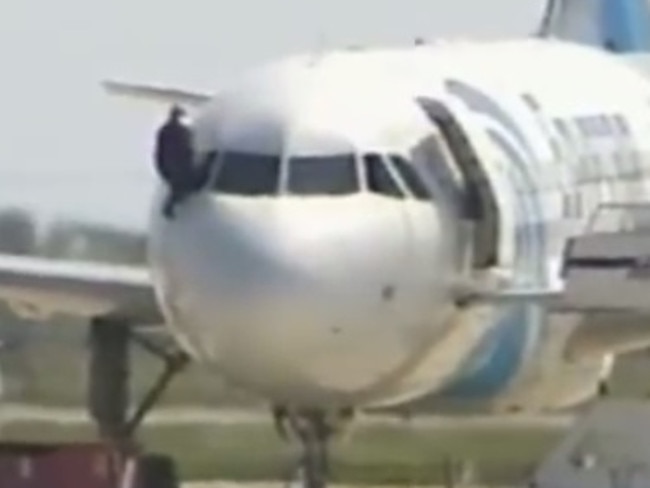 A man clambers out of the plane moments before the siege ends. Picture: SkyNews.