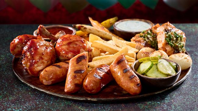 In the Mead Hall, you can get the Thawfest Platter – a Viking-like spread featuring chicken drumsticks glazed in a wild berry BBQ glaze, grilled salmon, and succulent sausage served with a medley of roasted carrots, Cipollini onions, Nordic fries, and side sauces. Photo: Universal Epic Universe