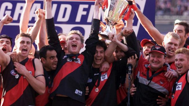 James Hird and Essendon footballers holding up the 2000 premiership cup.