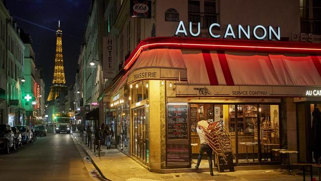 A bar owner closes up before the curfew comes into effect in Paris at 9pm. Picture: Getty Images