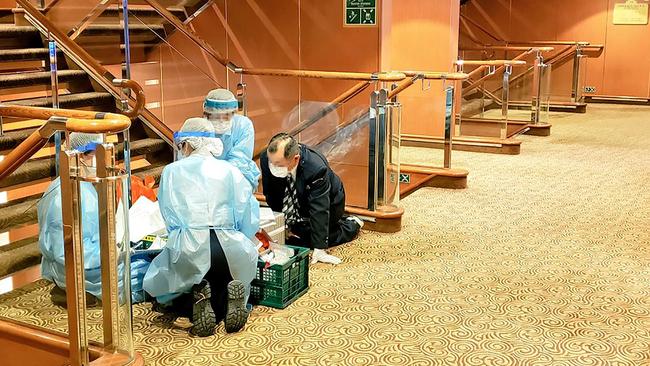 Officials in masks and protective clothing on one of the decks of the Diamond Princess cruise ship. Picture: AFP/@DAXA_TW