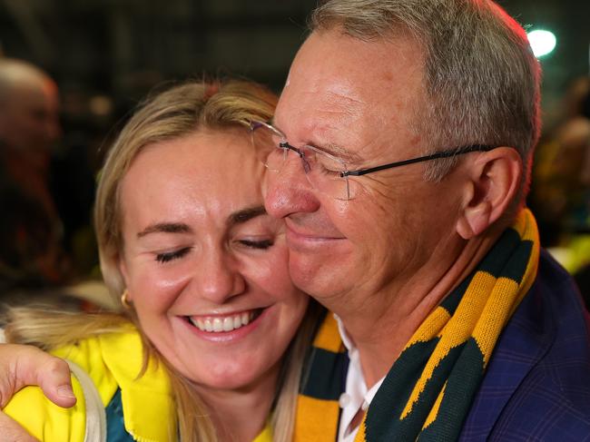 SYDNEY, AUSTRALIA - AUGUST 14: Ariarne Titmus hugs father Steve during the Australian Olympic Games athletes charter flight arrival at Sydney International Airport on August 14, 2024 in Sydney, Australia. (Photo by Jason McCawley/Getty Images)