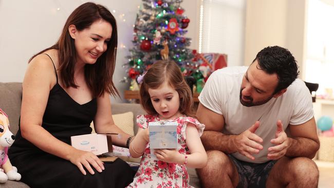 Pip and Todd Alexander and daughter Zara open presents in Sydney. Picture: Jane Dempster