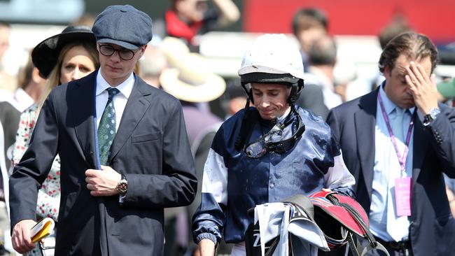 The Cliffsofmoher’s trainer Joseph O’Brien and jockey Ryan Moore walk from the track with their connections after the horse broke down early in the Melbourne Cup. Picture: Michael Klein