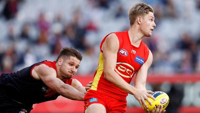 Max Spencer of the Suns runs with the ball under pressure from Jesse Hogan of the Demons during the Round 20 AFL match between the Melbourne Demons and the Gold Coast Suns at the MCG in Melbourne, Sunday, August 5, 2018. Picture: AAP Image, Daniel Pockett.