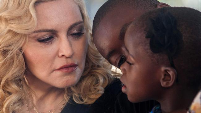 US popstar Madonna, her son David Banda (C) and one of her newly adopted daughters attend the opening ceremony of the Mercy James Children's Hospital named after her at Queen Elizabeth Central Hospital in Blantyre, Malawi on July 11, 2017. Madonna on July 11 took her four adopted Malawian children back to their home country for the opening of a paediatric hospital wing that her charity has built. / AFP PHOTO / AMOS GUMULIRA