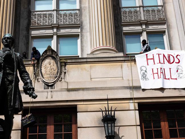 Pro-Palestinian protesters who are occupying Hamilton Hall lift a milk crate with supplies at Columbia University on April 30, 2024 in New York City. Picture: AFP