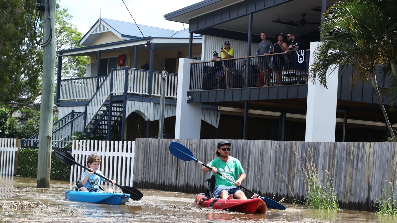 Residents of Tumbulgum paddle their kayaks down a street in Northern NSW. Picture: AAP Image/Jason O'Brien