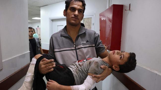 A Palestinian man carries a wounded youth in a hospital after an Israeli strike on Rafah in the southern Gaza Strip. Picture: Mohammed Abed/AFP