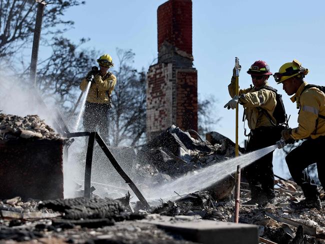 CAMARILLO, CALIFORNIA - NOVEMBER 08: Los Angeles Fire Department Station 105 firefighters hose down hotspots at a home which was destroyed in the Mountain Fire on November 8, 2024 in Camarillo, California. Fueled by strong winds, the fire has burned across more than 20,000 acres and destroyed over 100 structures, many of which are homes, since it began November 6.   Mario Tama/Getty Images/AFP (Photo by MARIO TAMA / GETTY IMAGES NORTH AMERICA / Getty Images via AFP)